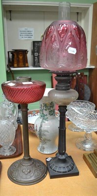 Lot 44 - A 19th century oil lamp with cranberry glass well and embossed copper base; and another with...