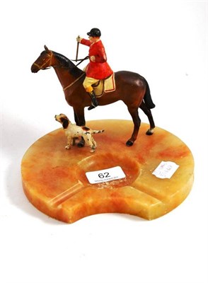 Lot 62 - A cold painted spelter figure of a huntsman on horseback with a shaped onyx ashtray