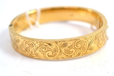 Lot 84 - A 9ct gold half engraved hinged bangle