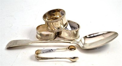 Lot 90 - A George IV silver fiddle pattern table spoon, London 1827, three silver napkin rings and a pair of