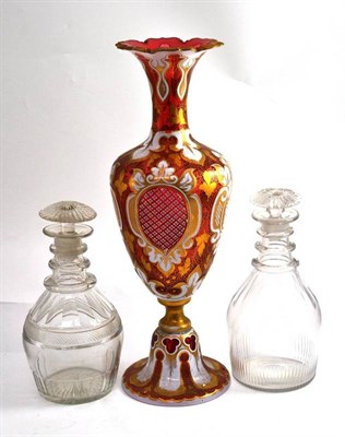 Lot 142 - A pair of triple ring neck glass decanters and stoppers; and a cranberry glass pedestal vase...