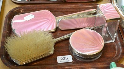 Lot 228 - Dressing table set in silver and pink enamel comprising hand mirror, two brushes and two lidded...