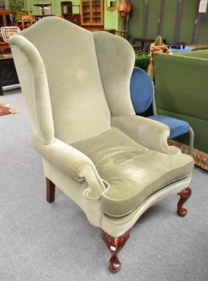 Lot 537 - Reproduction mahogany framed wing armchair with pale green velvet type upholstery