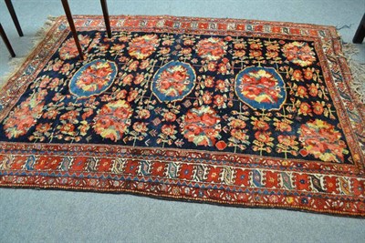 Lot 557 - Luri Rug, West Persia, the indigo field decorated with naturalistic flowers enclosed by ivory...