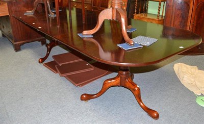 Lot 585 - A modern mahogany twin pedestal dining table with two extra leaves and table protectors