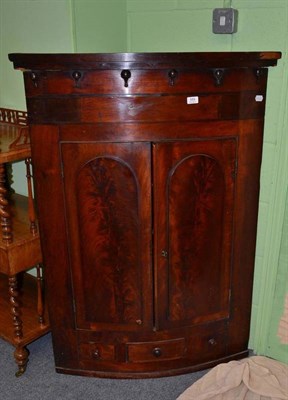 Lot 589 - A 19th century bow front mahogany corner cupboard