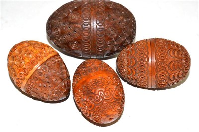 Lot 100 - Four carved coquille nuts