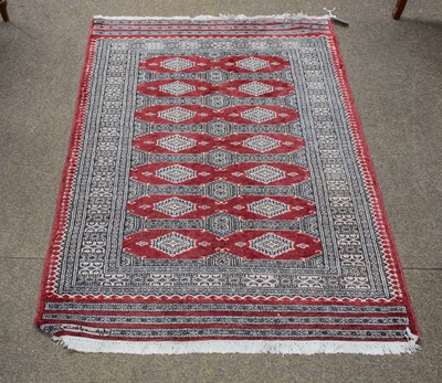 Lot 1286 - "Bukhara" Rug, the claret field with two...
