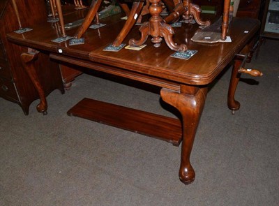 Lot 684 - An Edwardian mahogany wind out dining table with two leaves