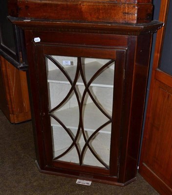 Lot 787 - A glazed mahogany hanging corner cupboard and key