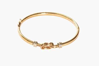 Lot 49 - A 9 Carat Bi-Colour Gold Bangle, with central...