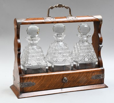 Lot 1127 - An Oak Three Bottle Tantalus, with silver...