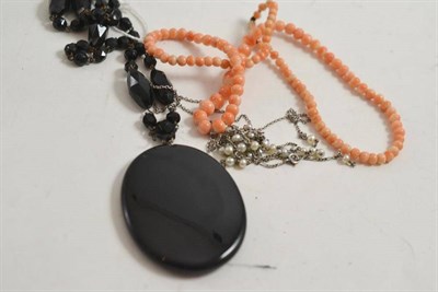 Lot 78 - A French jet locket on chain, coral necklace and a seed pearl set necklace