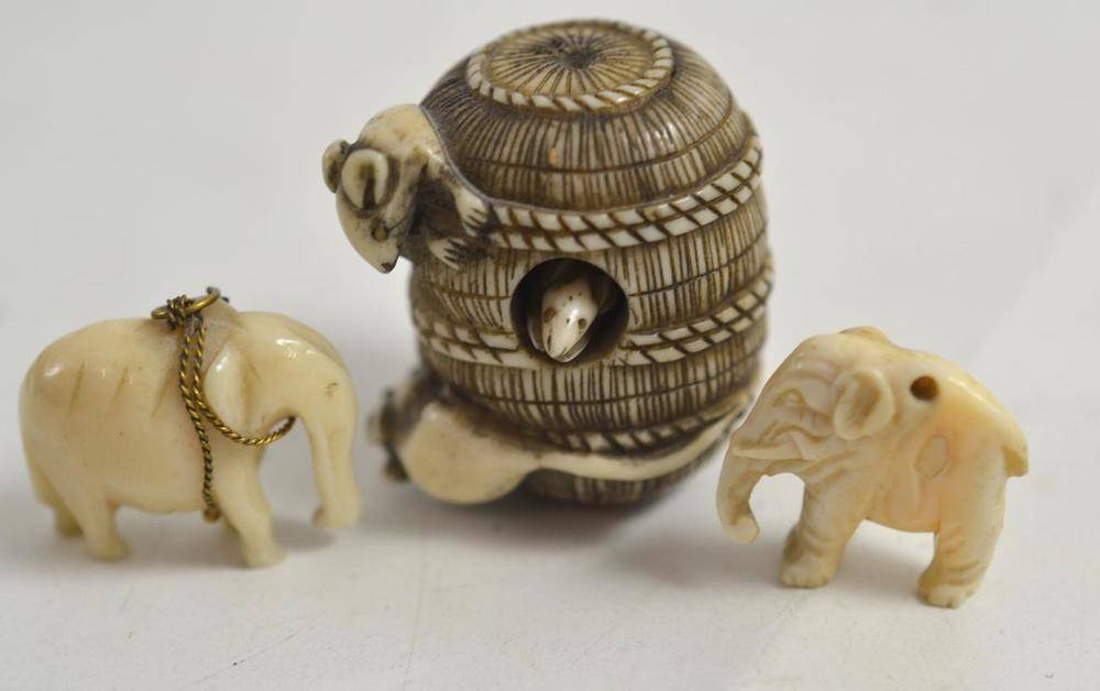 Lot 84 - A Japanese ivory netsuke as a rice bale with rats, two small ivory elephants