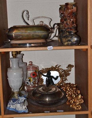 Lot 112 - Plated entree dishes and covers, an alabaster lamp, soapstone figures etc on two shelves