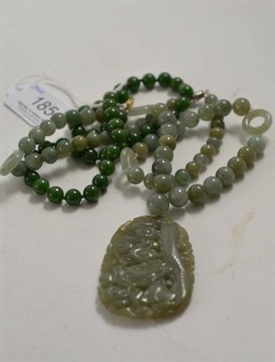 Lot 185 - A jade type bead necklace and a pair of earrings and another necklace with carved pendant