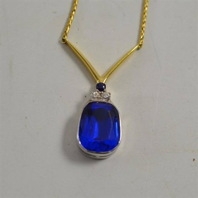 Lot 189 - An 18ct gold necklace, a large blue paste in a white rubbed over setting, surmounted by two old cut