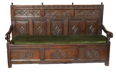 Lot 447 - An 18th Century Carved Oak Box Settle, with...
