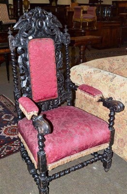 Lot 539 - A Victorian heavily carved oak elbow chair with red tasselled upholstery