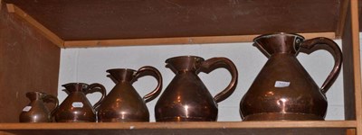 Lot 102 - A graduated set of six copper measuring jugs, marked 'GR'