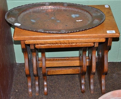 Lot 152 - A nest of three Arts & Crafts style oak tables and an Arts & Crafts oval tray