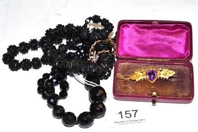 Lot 157 - A carved jet bead necklace (a.f.), a curb and lock bracelet, a brooch and a French jet necklace