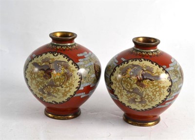 Lot 302 - A pair of Japanese cloisonne vases decorated with dragons and birds on a red ground