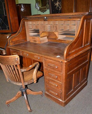 Lot 423 - An early 20th century oak tambour fronted desk and an office chair