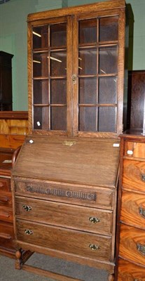 Lot 427 - A 1930s oak bureau bookcase