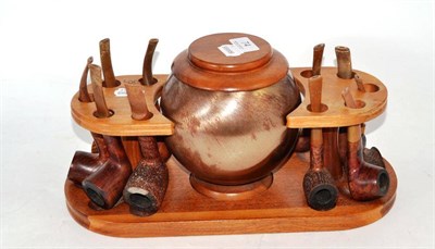 Lot 74 - A teak pipe rack/tobacco jar with a collection of fourteen various pipes