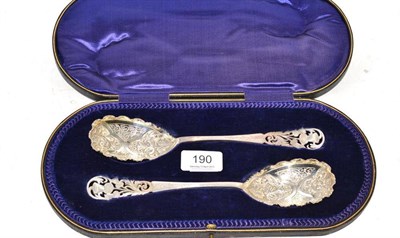Lot 190 - A pair of Edward VII pierced and chased silver berry spoons, Sheffield 1908, HH & S, cased