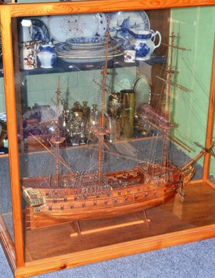 Lot 255 - A wooden model of a three masted warship with two banks of cannons, in a glazed oak case