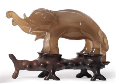 Lot 163 - A Chinese Carved Agate Elephant, late Qing Dynasty, the stylised quadruped leaning forward with...