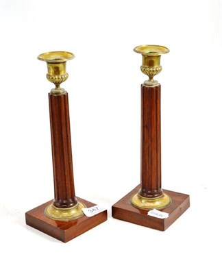 Lot 347 - A pair of mahogany column candlesticks with brass mounts