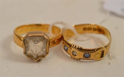 Lot 493 - An 18ct gold diamond and sapphire set buckle ring and a rock crystal intaglio ring (hallmark...