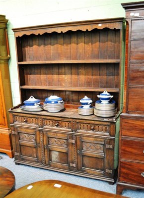 Lot 522 - An early 20th century carved oak enclosed dresser with rack, 145cm wide