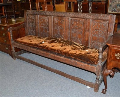 Lot 560 - An 18th century oak settle with five carved panels and open base, 196cm wide