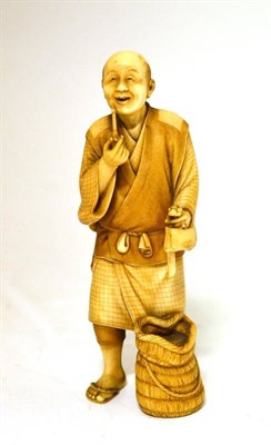 Lot 186 - A Japanese Ivory Okimono, Meiji period, as a man standing in traditional dress, a pipe in his right