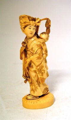 Lot 188 - A Japanese Ivory Okimono, Meiji period, as a girl in traditional costume with head scarf carrying a