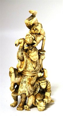 Lot 189 - A Japanese Ivory Okimono, Meiji period, as a warrior holding a sword, an oni above his head,...