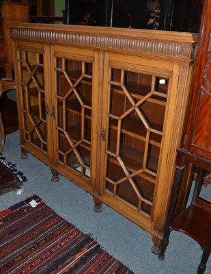 Lot 635 - An early 20th century carved oak enclosed bookcase with three astragal glazed doors, 161cm wide