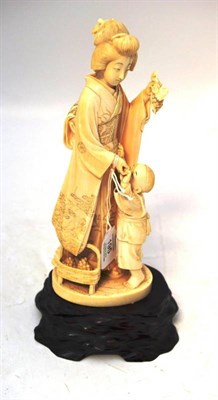 Lot 195 - A Japanese Ivory Okimono, Meiji period, as a mother standing wearing flowing robes, a bunch of...
