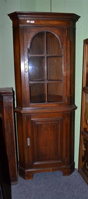 Lot 655 - A reproduction oak floor standing corner cabinet, 191cm high