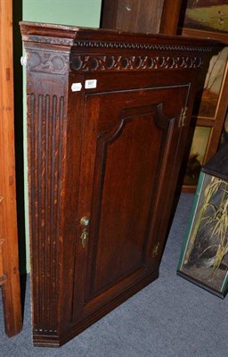 Lot 657 - A George III oak straight fronted wall hanging corner cupboard