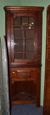 Lot 660 - An oak straight fronted floor standing corner cabinet