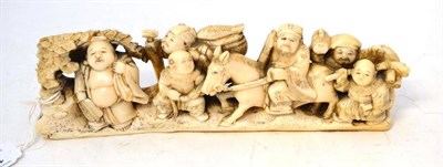 Lot 196 - A Japanese Carved Walrus Tusk Okimono, Meiji period, as a sage on horseback with various attendants
