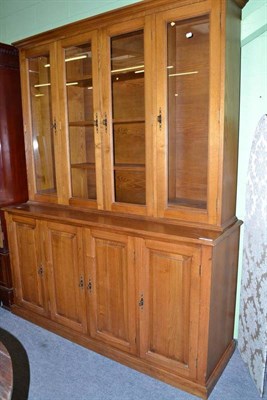 Lot 661 - A reproduction chestnut cupboard made by T.Johnson, the four glazed cabinet doors over four...