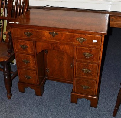 Lot 678 - A reproduction walnut kneehole writing desk in George II style with a feather banded quartered top