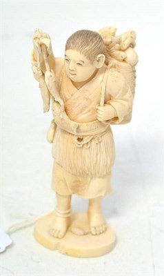 Lot 202 - A Japanese Ivory Okimono, Meiji period, as a boy carrying fish in one hand, a basket of fish...