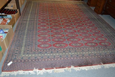 Lot 1315 - Lahore Bukhara carpet Pakistan, the maroon field with columns of guls enclosed by multiple...